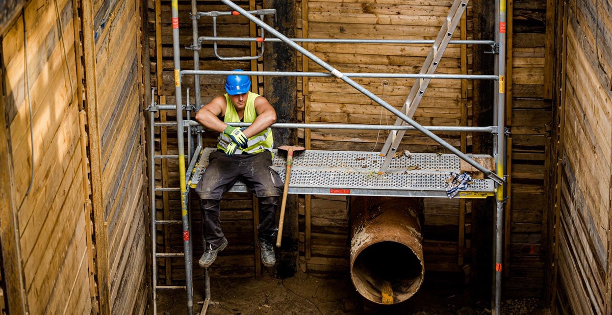 Bauarbeiter sitzt auf einem Baugerüst
